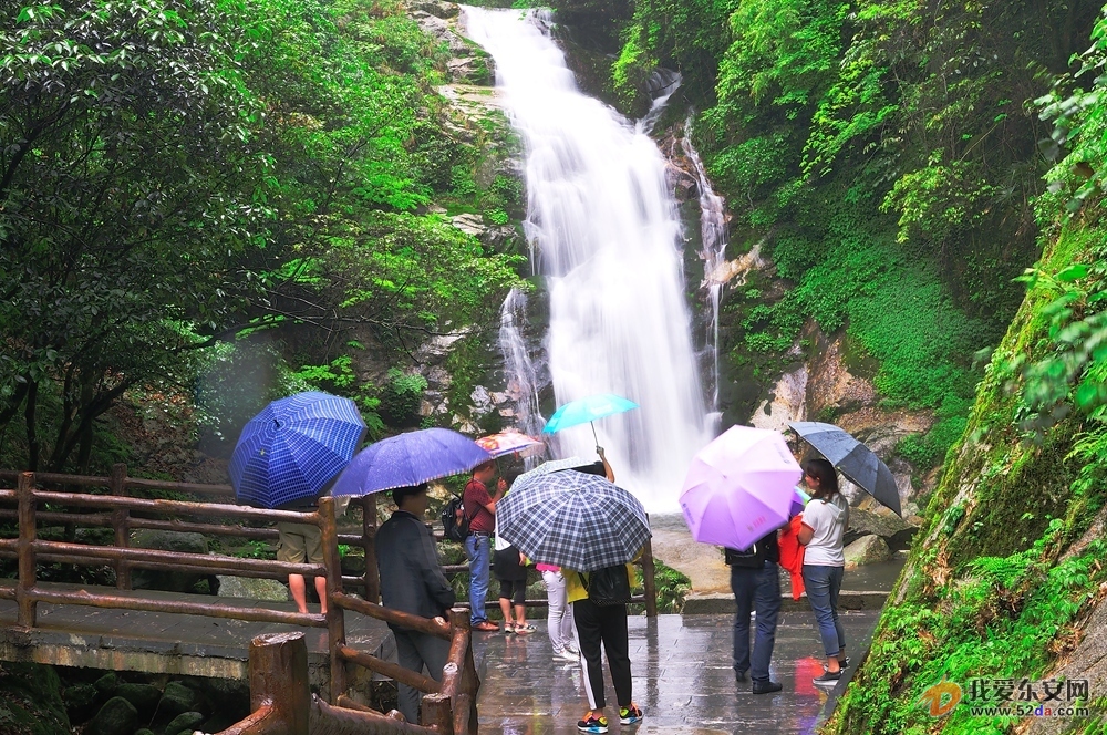 水流壮观，一群游客在冒雨观赏舜皇山瀑布